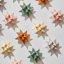Beautiful Pattern Of A Variety Origami Paper Stars On A Gray Background With Shadows. Holiday Composition. Flat Lay