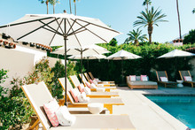 Sunbeds And Umbrellas In Swimming Pool Area In Upscale Californian Resort