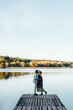© Alina Hvostikova/Stocksy - Couple kissing on pier of beautiful lake near dog