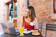 © Westend61 - Young blogger sitting at street cafe looking at laptop