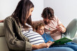 © Santi Nunez/Stocksy - Adorable happy family reading a book at home