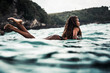 © Olga Sinenko/Stocksy - Young indonesian woman on a surf board in the ocean