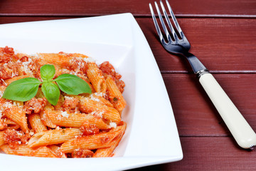 Canvas Print - Penne with tomatoes sauce and parmesan in a plate