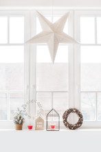 Christmas Decoration On A Window Sill And A Large Paper Star Hung Up
