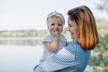 Happy Mother With Her Baby Daughter Outdoors