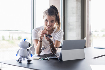 Smiling young woman working on technical equipment in office