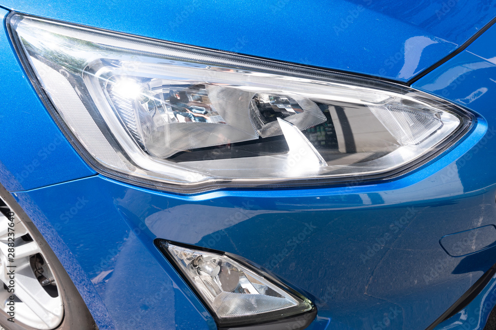 headlight detail of modern blue luxury car with projector lens for low high fog beam - obrazy, fototapety, plakaty 