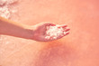 © Victor Bordera/ADDICTIVE STOCK - Woman's hand holding heap of salt in pink water