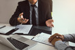 © wutzkoh - Smart businessman professional man in suit executive gesturing and talking in meeting with employee about work in modern office.