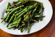 Spicy Szechuan Green Beans on white plate and wood surface