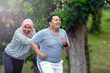© SVRSLYIMAGES - two people, with young Muslim women encouraging Asian male friends who are overweight to exercise that is running
