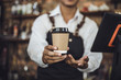 © Kris Tan - Male Barista preparing coffee for customer in coffee shop. Cafe owner serving a client at the coffee shop.