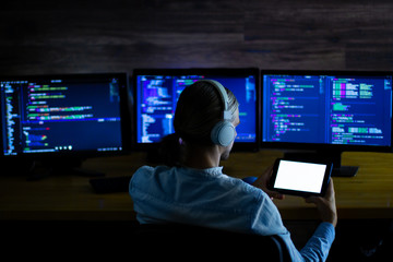 Wall Mural - software developer freelancer with white headphones and glasses working with program code: c++, java