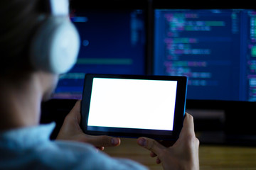 Wall Mural - software developer freelancer with white headphones and glasses working with program code: c++, java