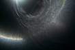 © golubovy - Blur rainbow lens flare on dark abstract background. Round spotlight rays and beams effect.