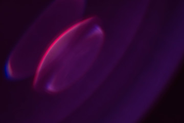 Wall Mural - defocused glow. dark purple abstract art background. colored lens flare. blur round flash light.