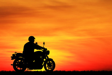 Canvas Print - Silhouette biker with his motorbike beside the natural lake and beautiful sunset sky.