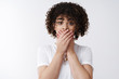 © Cookie Studio - Awkward cute curly-haired silly alluring girl slept secret feel sorry say oops cover mouth palms pressed lips say something inappropriate, standing white background worried stunned