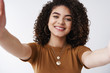 © Cookie Studio - Close-up friendly cheerful attractive girlfriend hold camera stretch arms taking selfie digital tablet talking boyfriend videocall smiling joyfully hugging friend standing white background