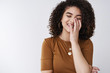 © Cookie Studio - Happiness, joy, summer concept. Cheerful carefree young positive curly-haired stylish girl laughing sincere close eyes cover white teeth palm giggling funny joke standing joyful white background