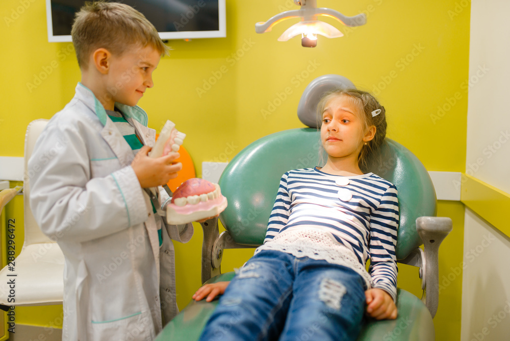 Little boy in uniform playing dentist, playroom - obrazy, fototapety, plakaty 