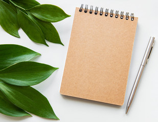 craft notebook and green leaves