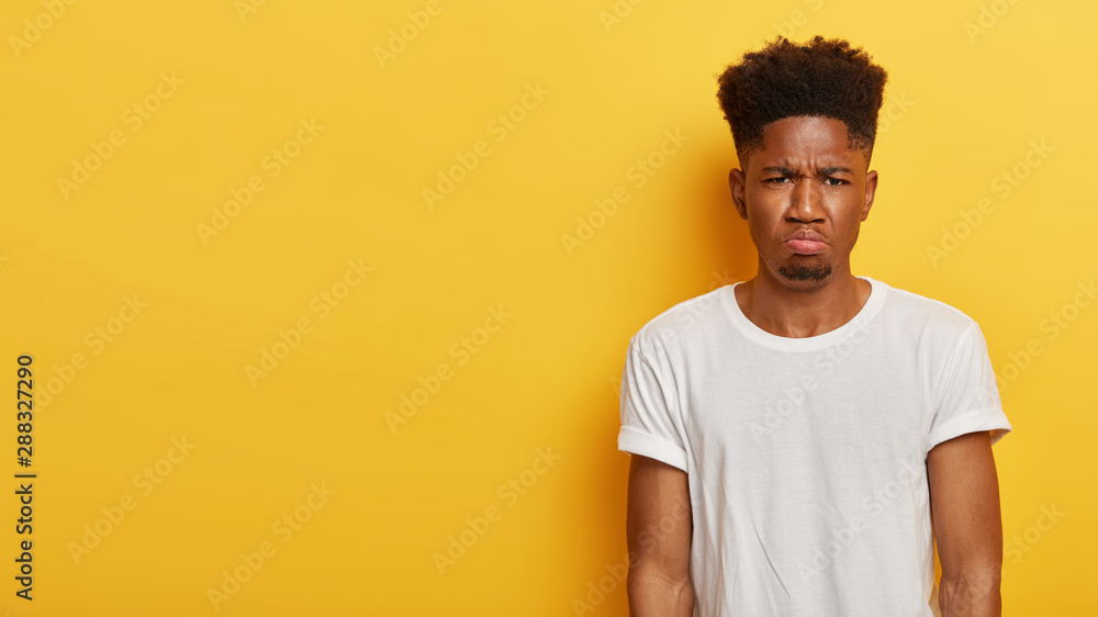 Photo of dejected displeased dark skinned man dislikes something, being ...