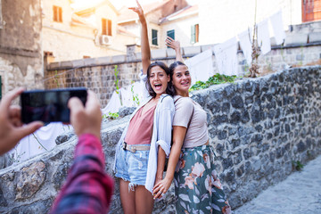 Wall Mural - Two female friends photographed by friend on smartphone