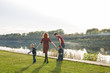 © satura_ - Childhood and nature concept - Family walking by the water