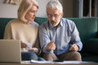 © fizkes - Elderly husband and wife calculate finances paying bills online