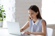 © fizkes - Focused young woman busy working on laptop in office
