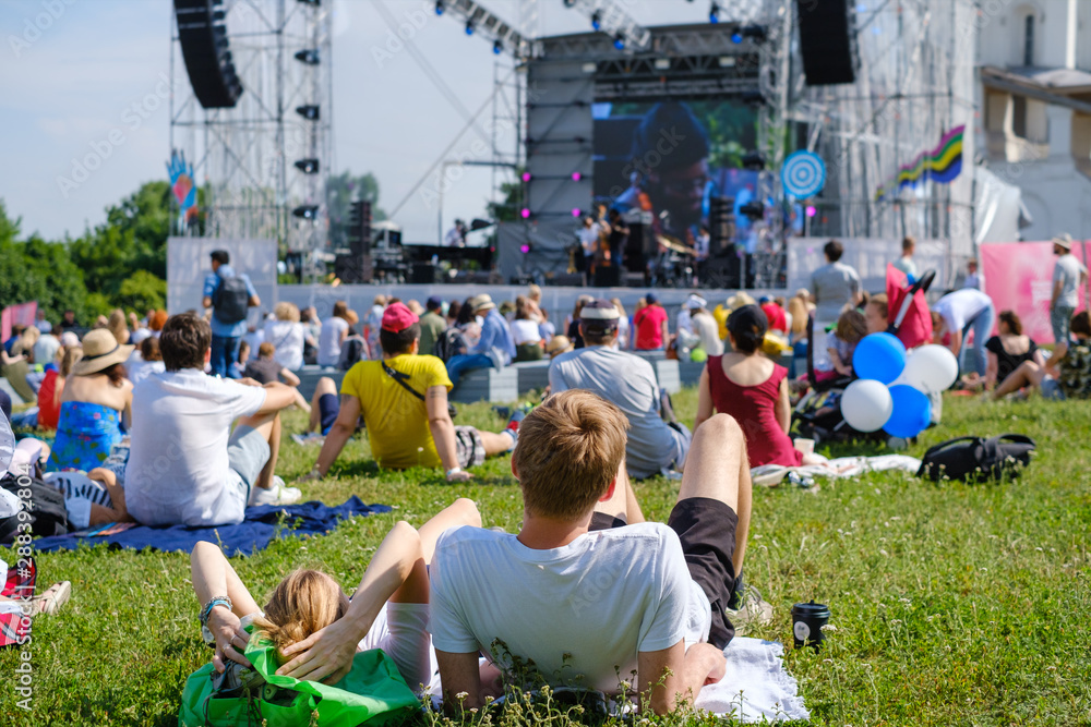 Couple is watching concert at open air music festival - obrazy, fototapety, plakaty 