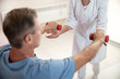© Yakobchuk Olena - Male patient is holding dumbbells in hands