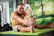 © Yakobchuk Olena - Happy adult patient is sitting on the mat
