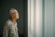 © Creativa Images - Lonely old man standing near the window