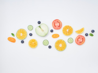 Wall Mural - Fresh fruits and vegetables sliced on white background