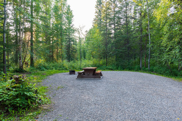 empty campsite with picnic table in liard river hot springs provincial park, british columbia, canad