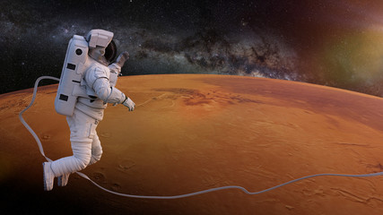 Wall Mural - astronaut during a space walk above the surface of planet Mars 