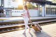 © Богдан Маліцький - attractive girl is standing with luggage at the station and waiting for the train, the student is going on a trip, she is walking along the platform, copy space