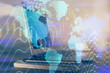 © peshkova - Forex market graph hologram and personal computer on background. Multi exposure. Concept of investment.