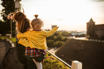 mom with dreadlocks shows the city to the child