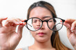 Asian woman holding glasses on white background, Selective focus on glasses , myopia and eyesight problem concept.