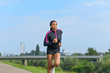 © michaelheim - Athletic young woman jogging outdoors in summer