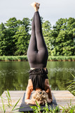 Fototapeta Pomosty - Młoda kobieta ćwicząca jogę nad jeziorem. Instruktor jogi. Asana. Na świeżym powietrzu. 