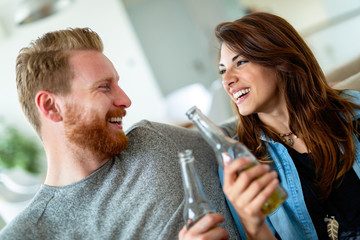 Poster - Young couple drinking and celebrating together at home