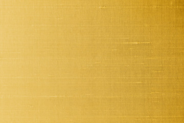 Gold silk fabric background of satin texture cotton cloth pattern with shiny gradient silky woven detail