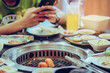 People grilling meat on a smokeless barbecue grill in a restaurant. Selective focus on shrimps.