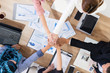 © InfiniteFlow - Businessmen and businesswomen joining hands in group meeting at multicultural office room showing teamwork, support and unity in business. Diversity workplace and corporate people working concept.