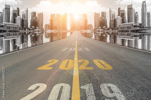Fotomural The number 2020 symbol represents the new year on the road heading to the city with beautiful skyscrapers background, New Year's and business target concepts
