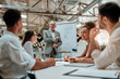 © Kostiantyn - New business strategy. Mature businessman standing near whiteboard and explaining something to his colleagues